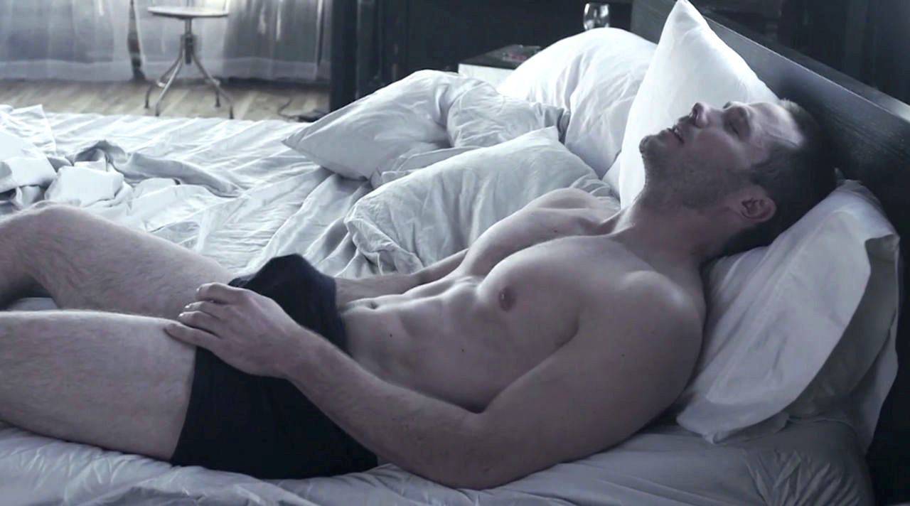 Luke Macfarlane in bed in his underwear